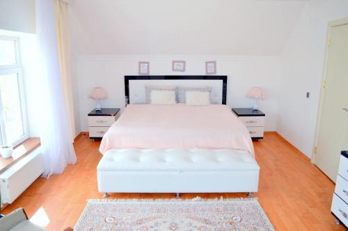 巴库Garden Cottage near Beach, Airport的白色卧室,配有白色的床和2个床头柜
