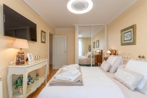 埃尔希耶戈Room Elciego的客厅配有白色的床和电视