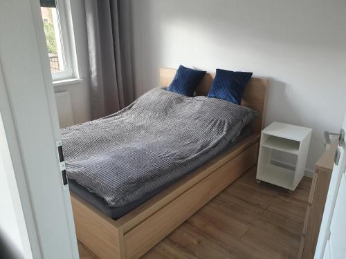 莱什诺Good Time Apartaments Sienkiewicza的一间卧室配有一张带蓝色枕头的床。