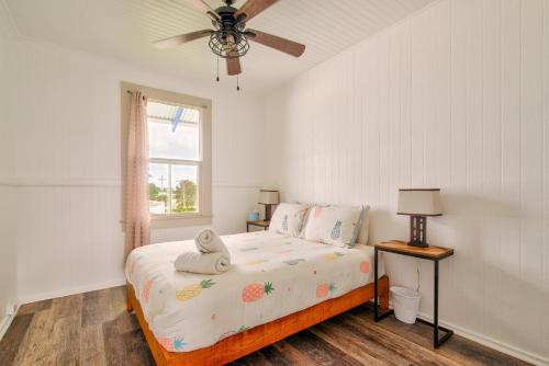 希洛NEW - Pineapple Loft - Entire House Downtown Hilo with AC的一间卧室配有一张带吊扇和窗户的床。