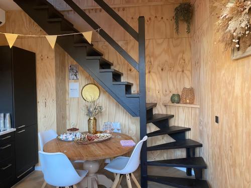 圣安娜兰Tiny House Thuus的一间带桌子和楼梯的用餐室