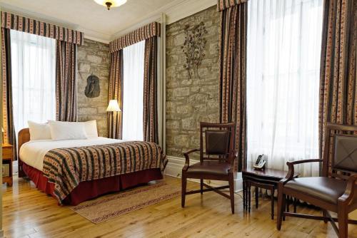 魁北克市河滨大道马努瓦尔酒店的酒店客房,配有一张床和两把椅子