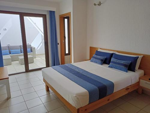 科蒂略Apartamento (Cotillo Mar) con vistas al Mar的一间卧室配有一张带蓝色枕头的床和一个阳台