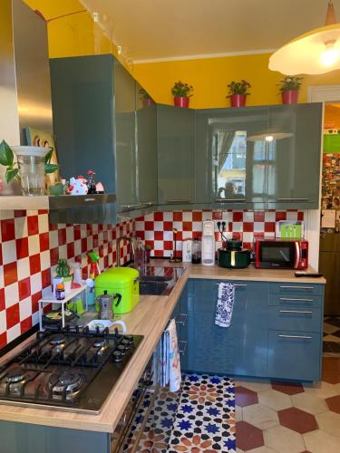 都灵Maria Vittoria House的厨房配有蓝色橱柜和红色及白色瓷砖