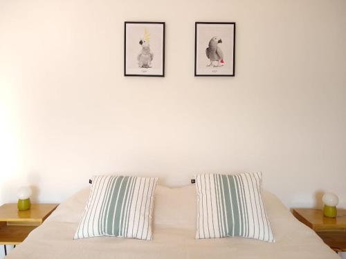 门多萨Buenaventura Apartment的卧室配有一张墙上三幅照片的床
