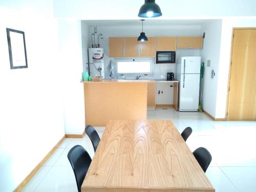 门多萨Buenaventura Apartment的厨房配有木桌和冰箱。