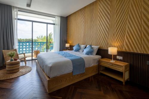 Gò CôngThe Stay Saigon Riverfront的一间卧室设有一张大床和一个大窗户