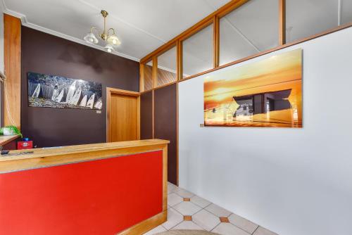 罗布Robe Central Motel的大堂设有红色柜台,墙上挂有绘画作品