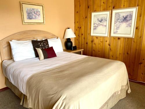 镭温泉Rocky Mountain Springs Lodge的卧室配有一张带白色床单和枕头的大床。
