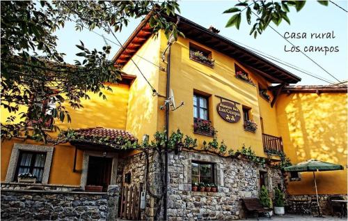 科里奥Casa Rural Los campos的黄色的建筑,带有石墙