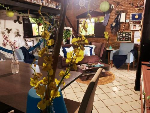 费尔南多 - 迪诺罗尼亚卡萨米尔特斯旅馆的客厅配有沙发和黄色花卉桌