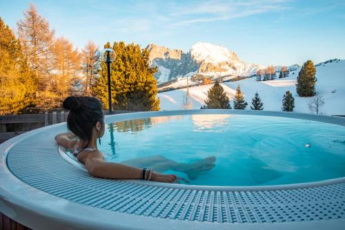阿尔卑斯休斯山Paradiso Pure Living Vegetarian-Vegan Hotel的坐在山里热水浴池中的女人