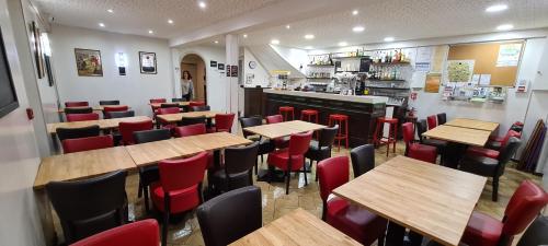 Saint-Alban-sur-LimagnoleAuberge Saint Jacques的餐厅设有木桌和红色椅子