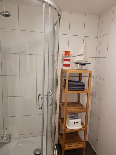 维林根Ferienwohnung Forsthaus的带淋浴的浴室以及带毛巾的架子。