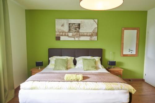 LinsbergGästezimmer Victoria的一间卧室设有一张带绿色墙壁的大床