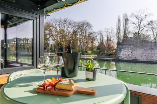 默兹河畔凡尔登Savy Hôtel的一张桌子,上面放着一盘食物和酒杯