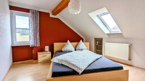 阿布斯贝格Ferienwohnung Schwalbennest am Igelsbachsee的一间卧室设有一张床和两个窗户。