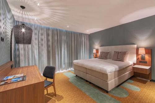 霍夫多普史基浦A4凡德瓦克酒店的一间卧室配有一张大床、一张桌子和一张书桌