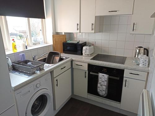 比勒瑞卡Froden Court的厨房配有水槽和洗衣机
