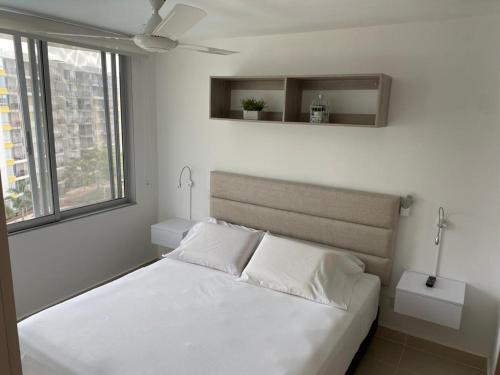 里考尔特Hermoso conjunto residencial con piscina!的窗户客房内的一张白色床
