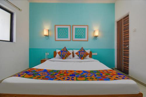 浦那FabHotel Aakiyo的一间卧室配有一张带蓝色墙壁的大床