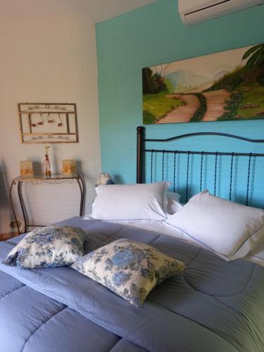 圣代佩德罗拉圣佩德罗旅馆的一张带两个枕头的床和墙上的绘画