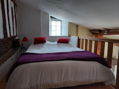 MontastrucStudio Bellevue 3 rue du bourg a Montastruc 47380 entrée indépendante的一间卧室配有一张带红色枕头的大床