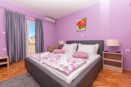 马卡尔斯卡Apps and room Goran in the center的一间卧室设有一张紫色墙壁的大床