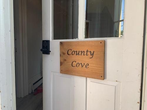 惠灵顿County Cove - Picton Suite的门上的标志,用来读取社区海湾