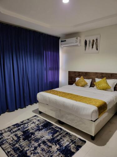 艾卜哈Al Mabeet 2 Hotel suites的一间卧室配有一张带蓝色窗帘的大床