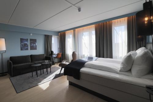 康斯博Clarion Collection Hotel Kongsberg的一间带大床的卧室和一间客厅