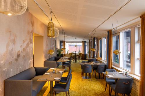 哥德堡船坞酒店的餐厅设有桌椅和窗户。