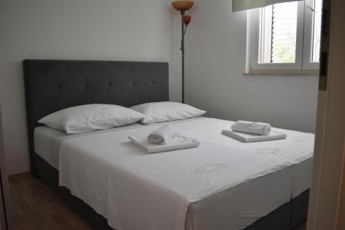 扎达尔Apartman DODO的一张白色的床,上面有两条毛巾