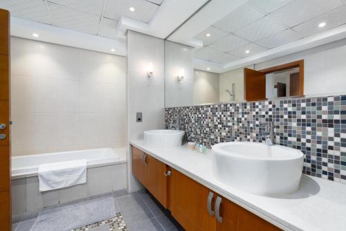 迪拜Dubai Marina Villa up 20 guest huge Private Pool的浴室设有2个水槽、浴缸和镜子