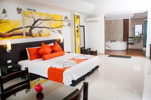 内瓦Hotel Abadia的一间卧室配有带橙色枕头的床和一间浴室