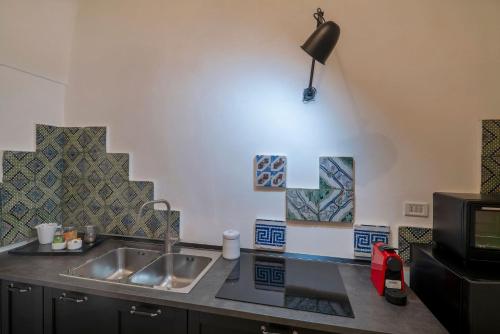 莱切B&B Corte Dei Romiti - Suites & Apartments SIT的厨房柜台设有水槽和微波炉