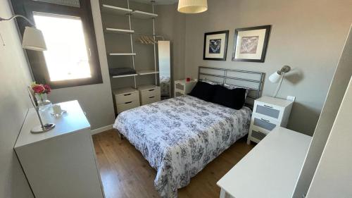 马斯帕洛马斯Apartamento en Playa del Ingles CC Yumbo的一间卧室配有床和两张白色桌子