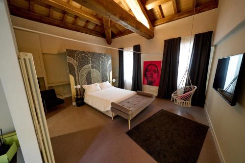 拉奎拉Ginevra Boutique Rooms - Palazzo Leosini - Residenze D'Epoca的一间卧室设有一张床和一些窗户。