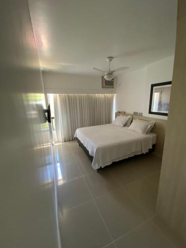 萨尔瓦多Apart Hotel em Ondina的卧室配有白色的床和窗户。