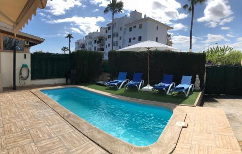 阿尔库迪亚港Casa Paraiso de Alcudia的一座带蓝色椅子的游泳池和一座建筑