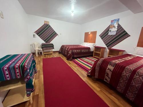 普诺Hotel Wiñay Pacha Inn的一间设有两张床和红地毯的客房
