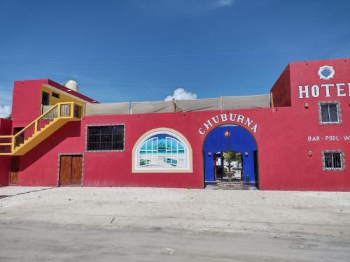 ChuburnáHotel Chuburna的一座红色的建筑,有一间蓝色的门的酒店