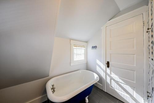 哈蒙兹波特Lake Daze的一间位于门边的带浴缸的白色浴室