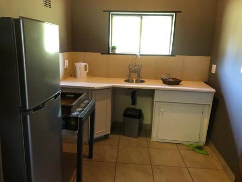 贝拉贝拉Ebenhaeser overnight accomodation的一间带水槽和冰箱的小厨房