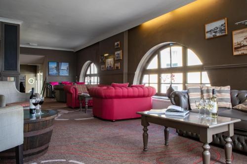 圣莫斯船堡酒店的客厅配有粉红色的沙发和桌子