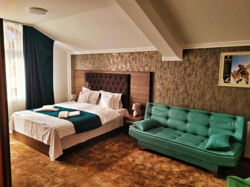 布什泰尼玛格丽塔酒店的一间卧室配有一张床和一张绿色沙发