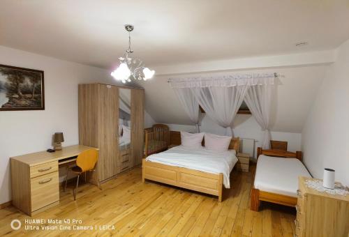 斯克拉斯卡波伦巴Dom Kasienka - Na Wyłączność的一间卧室配有一张床、一张桌子和一张四柱床。