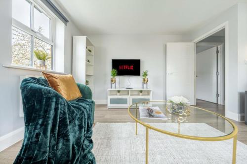 梅登黑德Super Luxe Central Maidenhead Apartment的客厅配有绿色沙发和玻璃桌