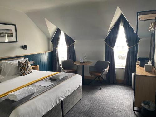 卡斯尔韦伦Hillyard House Hotel的酒店客房,配有一张床和一张桌子及椅子