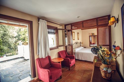 卡皮雷拉利亚诺斯庄园酒店的一间卧室配有一张床、两把椅子和一个窗户